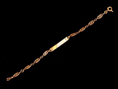 gros plan d'un bracelet en or sur fond noir