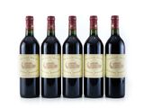 quatre bouteilles de vin sont alignées sur une surface blanche