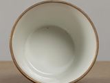 a close up of a white cup on a wooden table