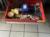 a red tool box filled with assorted items on a tiled floor