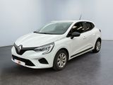 Une voiture blanche est garée dans une pièce au sol noir.