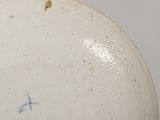 a white plate with blue writing on it on a table