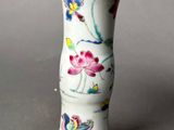 a white vase with flowers on it sitting on a table