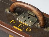 a brown suitcase with a yellow stripe on it