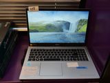 un ordinateur portable posé sur un bureau violet, à côté d'un livre