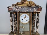 a clock with a dog on top of it sitting on a table