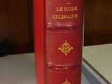 un livre rouge posé sur une table blanche