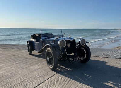 une voiture de collection garée sur la plage, près de l'océan