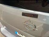 a close up of a silver car with a sticker on it