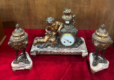 une horloge posée sur une table, à côté d'autres objets