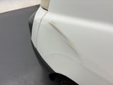 a close up of a white car with rust on the side of it