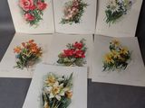 six cartes ornées de fleurs posées sur une table