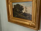 a painting hanging on the wall next to a chair