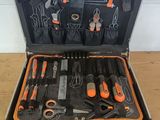 une trousse à outils dans un coffret posé sur une table en bois
