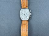 une image représentant une montre avec un bracelet marron sur un fond noir