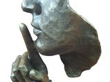 statue of a man holding a finger up to his lips