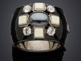 un gros plan d'une bague noire et blanche ornée d'une pierre au centre