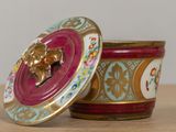 a small container that has a gold lion on it
