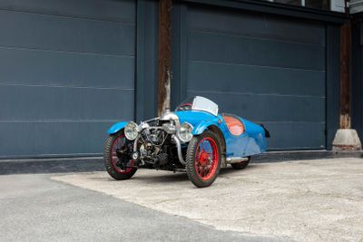 a blue and red car parked in front of a garage