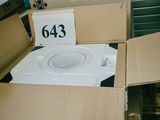 des toilettes blanches dans un carton sur lequel est accrochée une pancarte