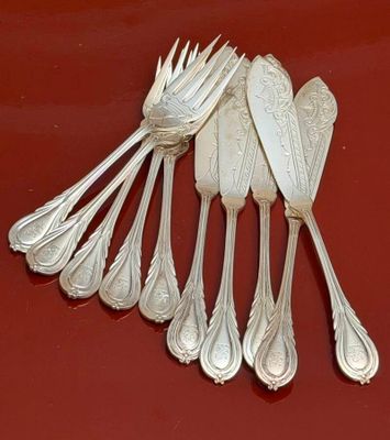 five silver spoons and six silver spoons on a red surface