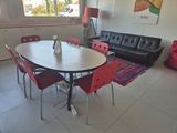 a room with a table, chairs and a couch in it