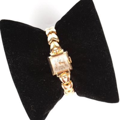un nœud papillon noir orné d'une montre en or