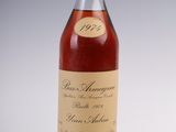 a bottle of wine sitting on top of a table next to a glass