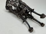 a metal sculpture of a cow laying down on the ground