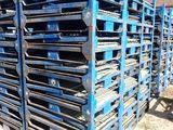 un tas de palettes posées au milieu d'un champ de terre battue