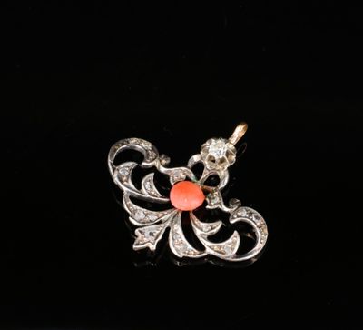un gros plan d'un pendentif en diamant et corail sur fond noir