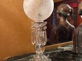 un vase en verre posé sur une table en marbre à côté d'un miroir