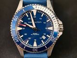 un gros plan d'une montre avec un bracelet bleu