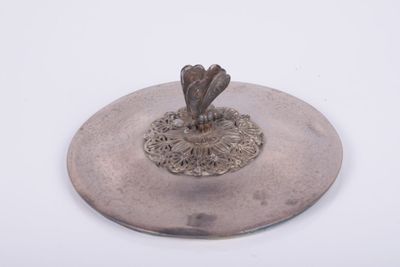 une assiette en argent ornée d'un oiseau sur fond blanc
