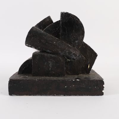 sculptures made of black wood stacked on top of each other on a white surface