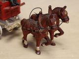 two horses pulling a wagon with a man in it