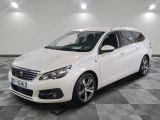 la voiture blanche est garée sur un sol en damier dans le garage