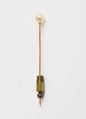 une broche en forme de perle et d'or sur fond blanc
