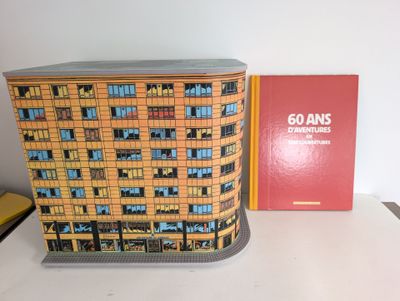 a model of a building on a table next to a book