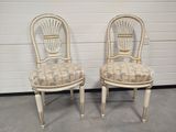 pair of white painted dining chairs with upholstered seat covers