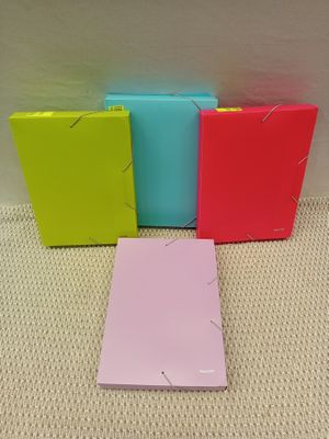 quatre classeurs de couleurs différentes posés sur une surface blanche
