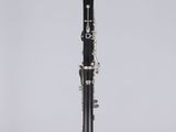 a black and white clarinet sitting on top of a clear stand