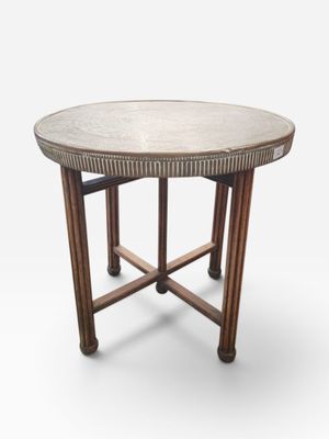 a round table with a metal top and wooden legs