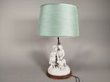 une lampe posée sur une table, avec un abat-jour vert