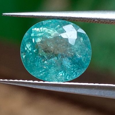 un gros plan d'un diamant bleu tenu par une pince