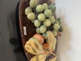 un bol de fruits posé sur une table sur laquelle se trouve une feuille