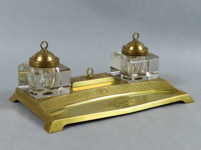 a gold desk set with two glass bottles on top of it
