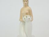 figurine représentant une femme tenant un bol dans ses mains