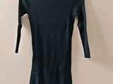 black turtle neck dress hanging on a hanger on a wall