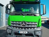 un camion vert garé devant un immeuble